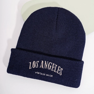 Gros plan de la broderie Los Angeles blanche sur un bonnet en maille bleu marine vintage