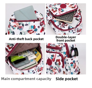 Detail view of floral nylon backpack compartments showing anti-theft pocket and storage layers