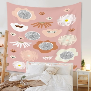Detail of bohemian pink floral wall tapestry hanging in a cozy bedroom setting