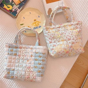 Detailed view of two quilted floral cotton handbags with soft texture and simple wish label