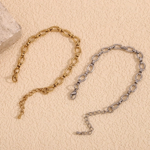 Minimalist 14K gold and silver stainless steel chain link bracelets on beige texture