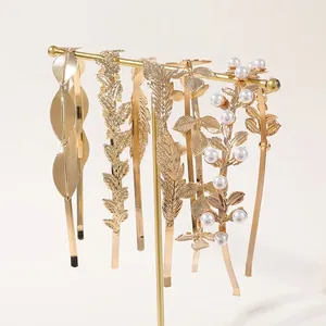 Bohemian gold metal leaf headbands with faux pearls on display for bridal styling