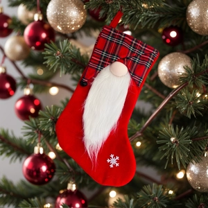 Red plaid Christmas stocking featuring a gnome with white beard and snowflake pattern