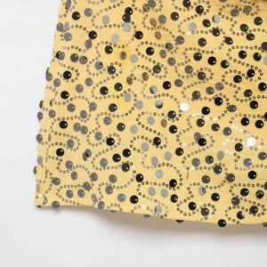 Sequin mini skirt with yellow fabric and black silver swirling beadwork patterns