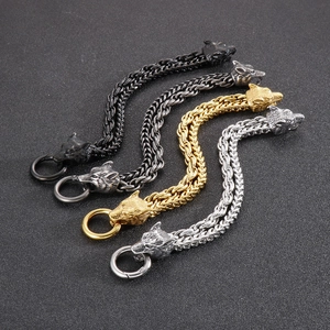 Close-up of four wolf head men's braided bracelets in gold, silver, and black finishes