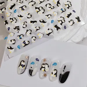 Cartoon penguin nail art stickers with fish and snowflake patterns in blue and gold