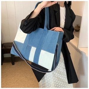 Detail of blue and white patchwork denim tote bag with striped shoulder strap for daily use