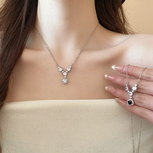 Primo piano di ciondoli geometrici in zircone quadrato e a V su catenine d'argento