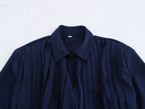 Detail of elegant navy satin dress neckline with pleats and size S label on white background