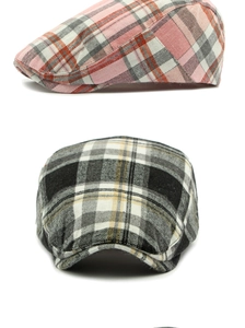 Detail view of pink and yellow plaid beret caps showing fabric texture and patterns