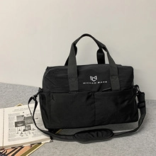 Detail of waterproof nylon gym bag featuring front pockets and adjustable strap