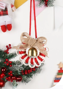 Macro view of a handmade red and white braided Christmas ornament with a golden bell