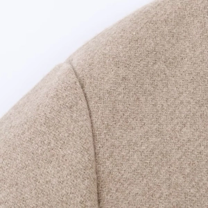 Gros plan sur la texture en laine et la couture d'épaule d'un manteau de couleur camel