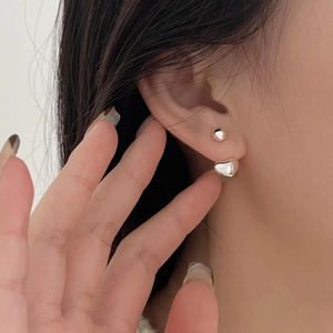 Minimalist 925 sterling silver heart drop earrings and bead studs worn by a model