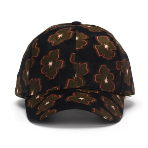 Close-up of baseball cap with dark floral pattern, green petals and red stitched edges