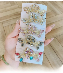 Close-up of elegant crystal butterfly hair clips in various colors with gold alloy frames