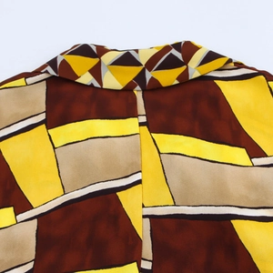 Detalle del cuello trasero mostrando la tela con patrón geométrico y corte de la blusa