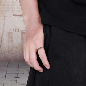 Detail of minimalist geometric faceted titanium steel ring in antique silver on model hand