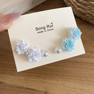 Detail of elegant 3D rose floral earrings with pearls on cream cardstock