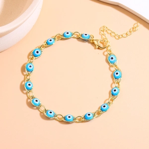 Close-up of golden Evil Eye bracelet with blue enamel beads and adjustable lobster clasp