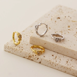 Close-up of S925 hallmark on silver and gold rose earrings with sparkling crystals