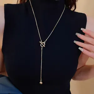 Minimalist gold Y-shaped snake chain necklace with OT toggle clasp and ball pendant on model