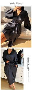 Detail shot of black satin wrap robe showing silk-like texture and deep V-neckline