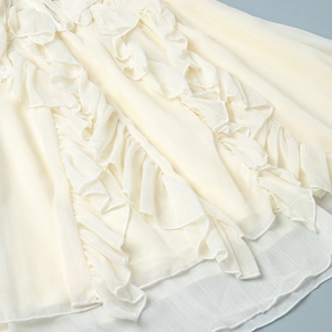 Close-up of layered ruffle details and delicate hem on ivory chiffon lantern sleeve dress