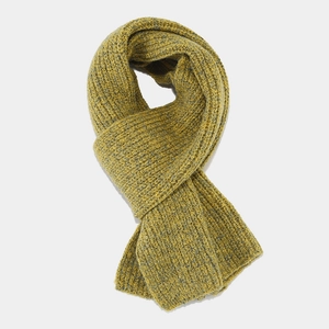Detail of chunky knit yellow scarf featuring ribbed texture and thick winter material