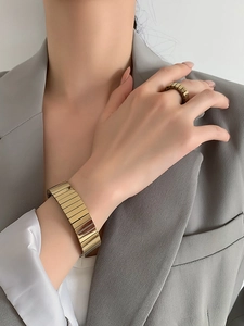 Polished gold watchband-style link bracelet and matching ring on model wrist