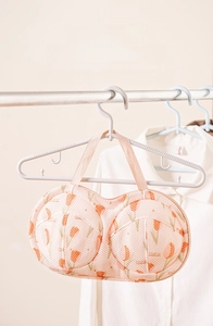 Detail of tulip pattern mesh laundry bag for bras hanging on a white hanger
