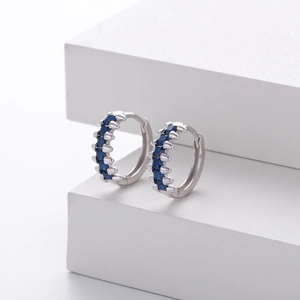 Close-up of S925 silver hoop earrings with blue sapphire zircon in a claw setting