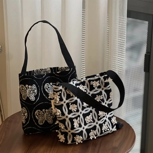 Vintage canvas hobo bag set with butterfly and floral embroidery on a wooden table