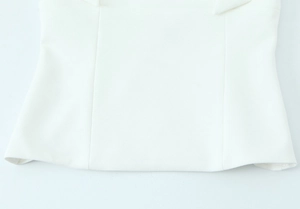 Detailed view of white slim-fit top featuring clean hemline and vertical stitching details