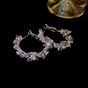 Detailed view of silver butterfly C-shaped hoop earrings with purple cubic zirconia crystals