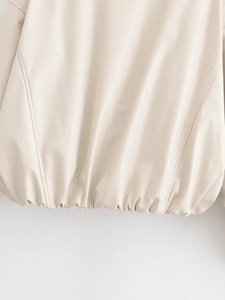 Detailed close-up of cream faux leather jacket hem featuring elastic pleated waist design