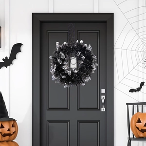 Ghirlanda di Halloween con fili neri e teschi d'argento appesa a una porta decorata