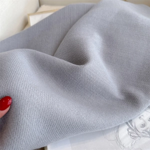 Detailed close-up of grey herringbone cashmere scarf fabric showing soft thick texture