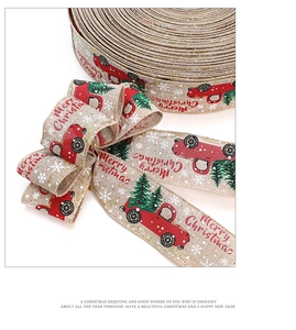 Macro shot of faux linen Christmas ribbon featuring red trucks and green trees prints