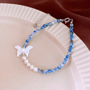 Detail of beaded necklace with blue beads and S925 sterling silver butterfly pendant