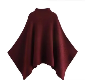 Détail de la cape en tricot bordeaux avec coupe asymétrique et texture de qualité