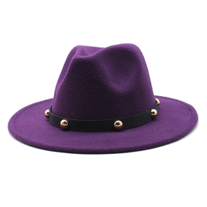 Detail of dark purple wool fedora hat featuring a black band with gold metallic studs