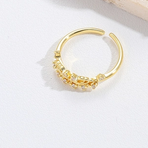 Macro shot of gold teardrop open ring featuring sparkling micro-pave cubic zirconia inlay