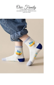 Close-up of children's warm terry socks with boat pattern and dino letter print