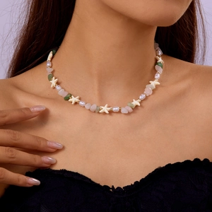 Detail of beaded necklace with natural shell, pearls, rose quartz and aventurine stones