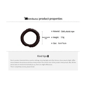 Detailed view of a brown pleated fabric scrunchie with 6cm diameter size specifications
