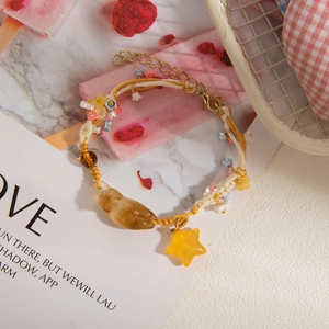 New Chinese orange beaded star woven bracelet with yellow star pendant on warm background