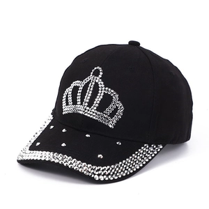 Detailed close-up of a black baseball cap with crystal crown design and studded brim