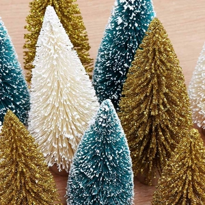Close-up of assorted gold, green, and white bottle brush mini Christmas trees on wood
