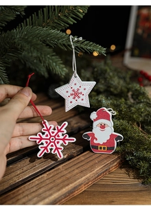 Close-up of wooden Christmas ornaments with snowflake and Santa Claus patterns